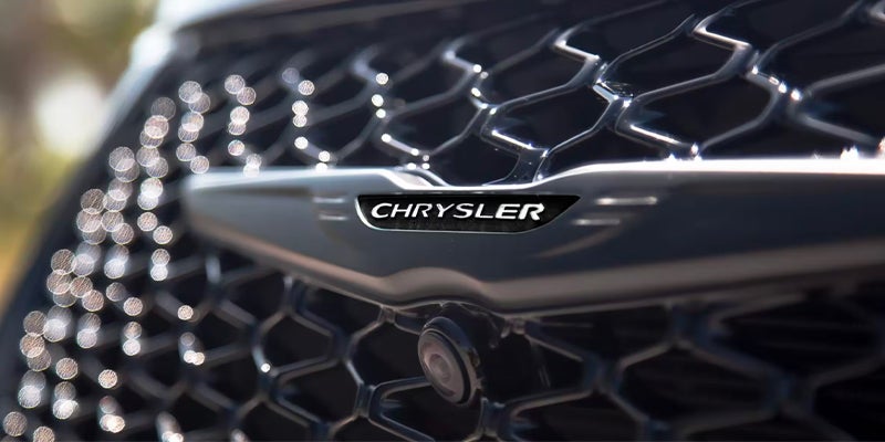 A close-up shot of the Chrysler logo on the front grille of a vehicle