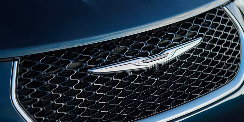 Close-up of a Chrysler grille with the winged badge and mesh pattern