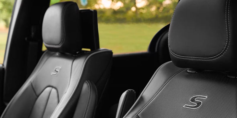 Close-up of black leather seats with an 'S' stitched logo