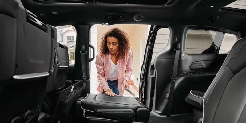 Woman folding a rear seat in a minivan's spacious interior