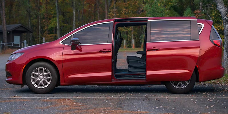  Red Chrysler minivan parked with both driver and passenger side doors open