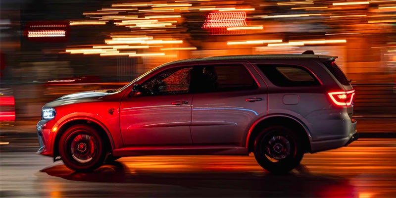 A side view of a vehicle in motion at night, with motion-blurred streaks of light in the background