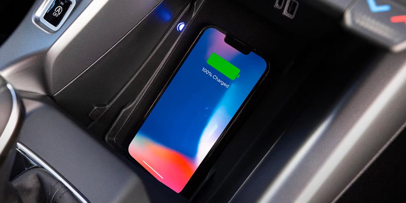Smartphone wirelessly charging in the car's center console cubby