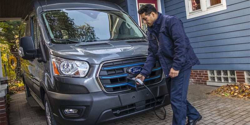 man plugging in a ford e-transit