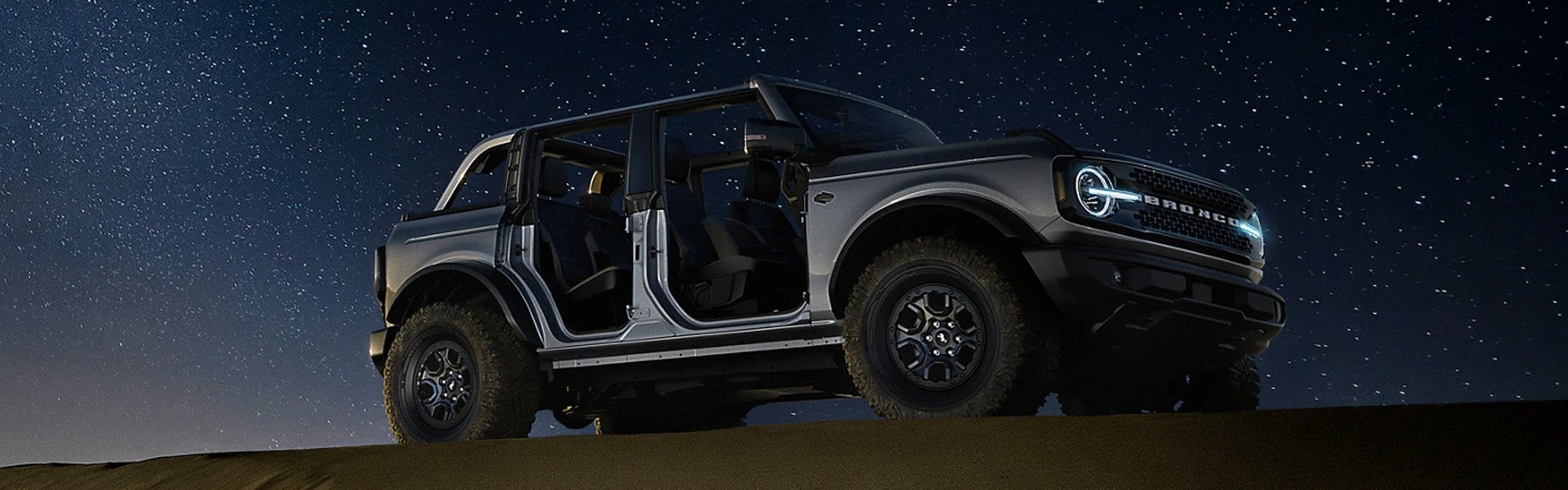 ford bronco under a starry night sky