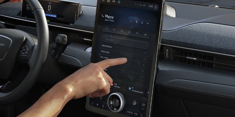 hand using the touchscreen of the ford mustang mach-e