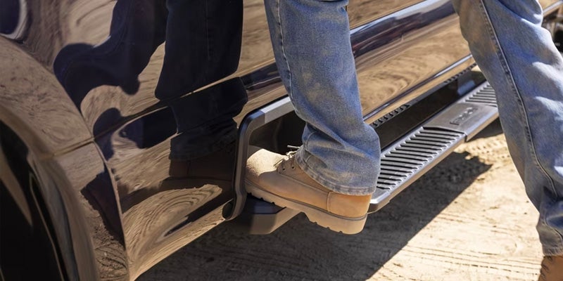A person stepping onto the side of a Ford Super Duty.