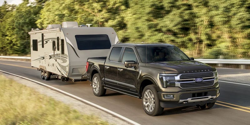 Ford F-150 truck towing a camper trailer.