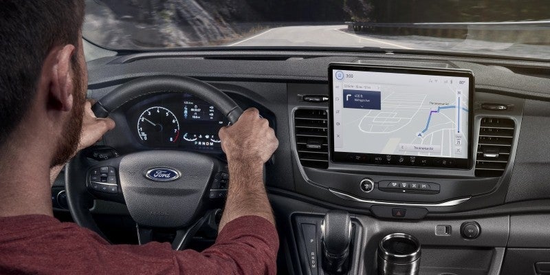 A person driving Ford transit van and viewing a map on the screen.