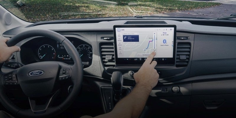 A person using the touchscreen display in a Ford transit van.
