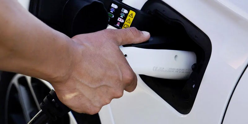 Hand plugging charger into Jeep SUV