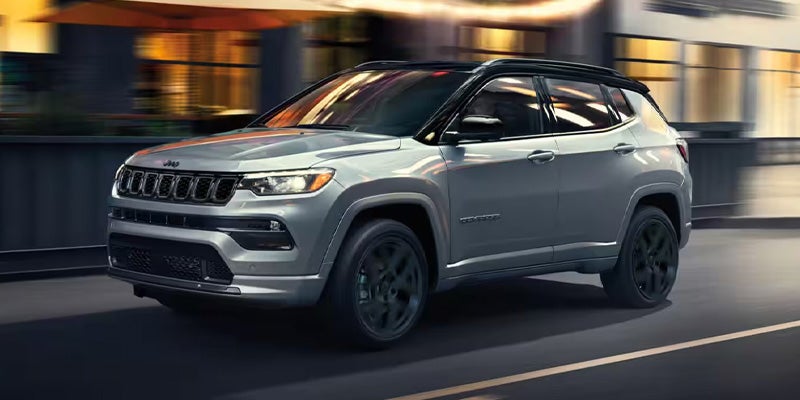 Silver Jeep Compass driving at night, showing motion blur