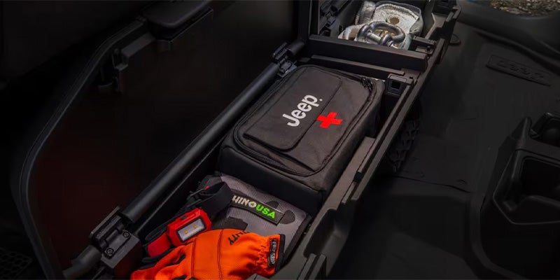 Under-seat storage compartment in the Jeep Gladiator, showing tools