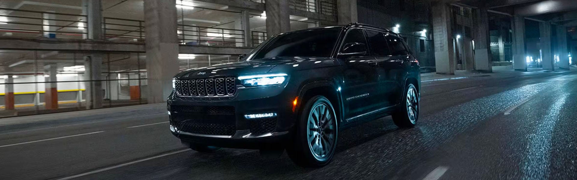 **Black Jeep Grand Cherokee** driving at night in an urban area.