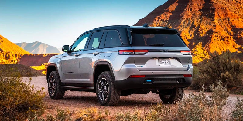 Silver Jeep Grand Cherokee rear view in a desert landscape