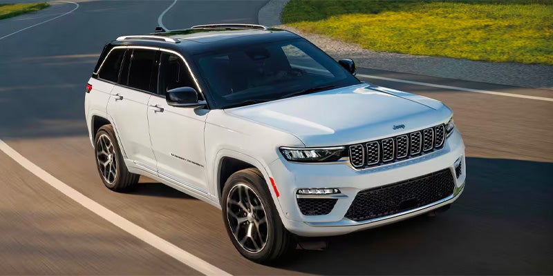 White Jeep Grand Cherokee L extended SUV driving
