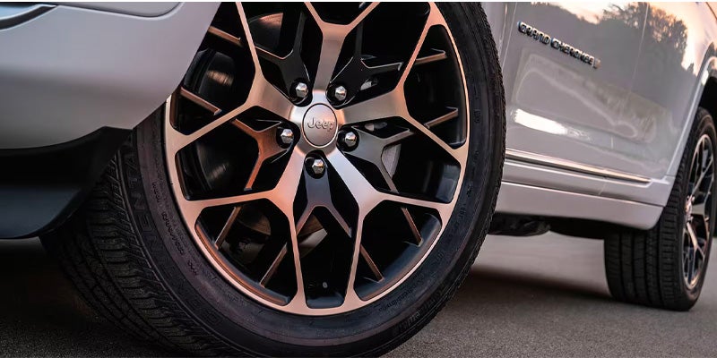 Close-up of the black and silver multi-spoke wheel on the Jeep SUV