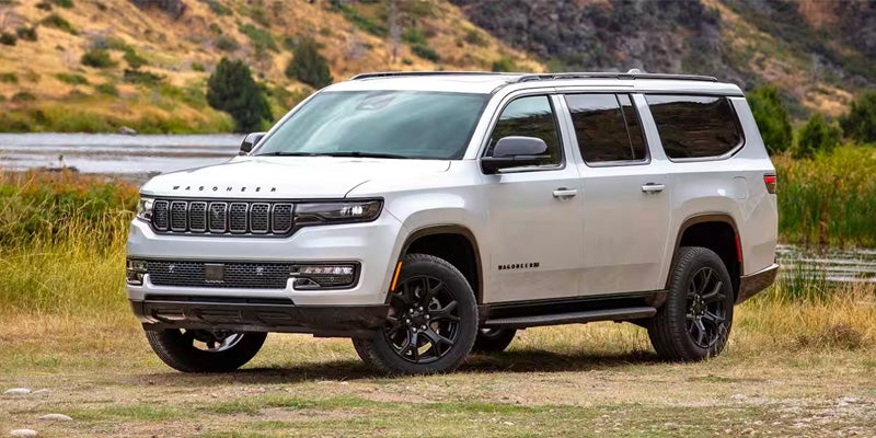 White Wagoneer SUV driving down a road