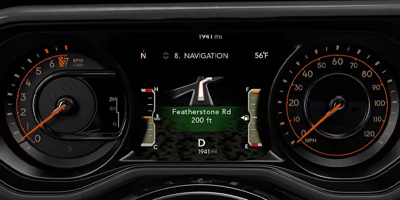The dashboard of a Jeep Wrangler shows a navigation screen and gauges