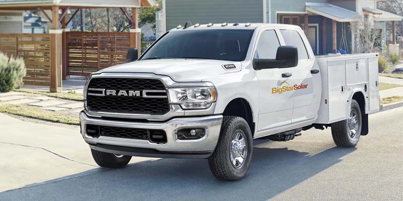 Front view of a white Ram Heavy Duty service body work truck parked on a suburban street