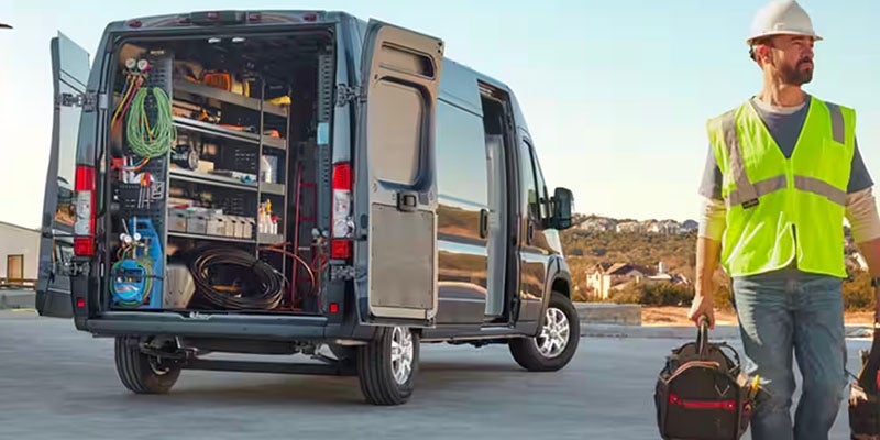 Gray Ram ProMaster rear open doors with tools; worker with safety vest