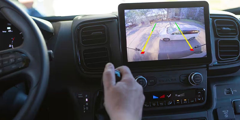 Driver's view of a large touchscreen display showing a backup camera feed
