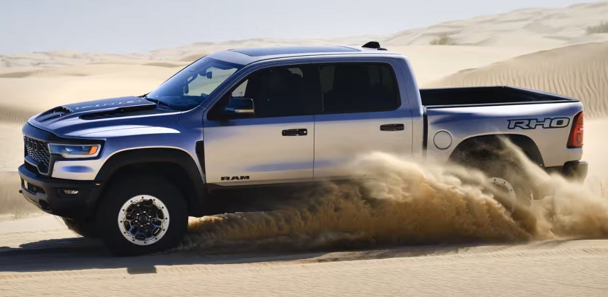 Ram RHO pickup truck speeding across desert sand